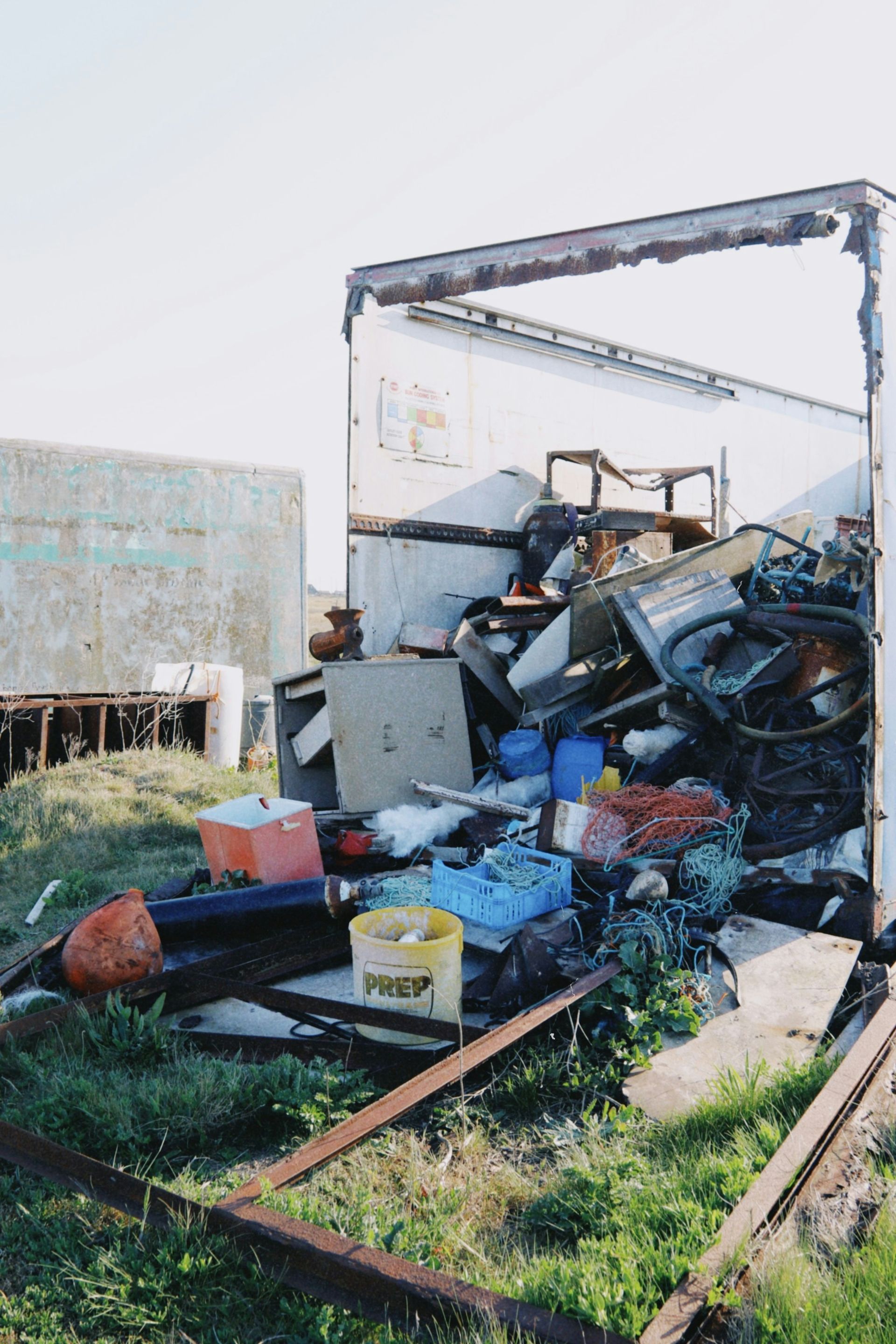 An overfilled trailer contains various types of trash